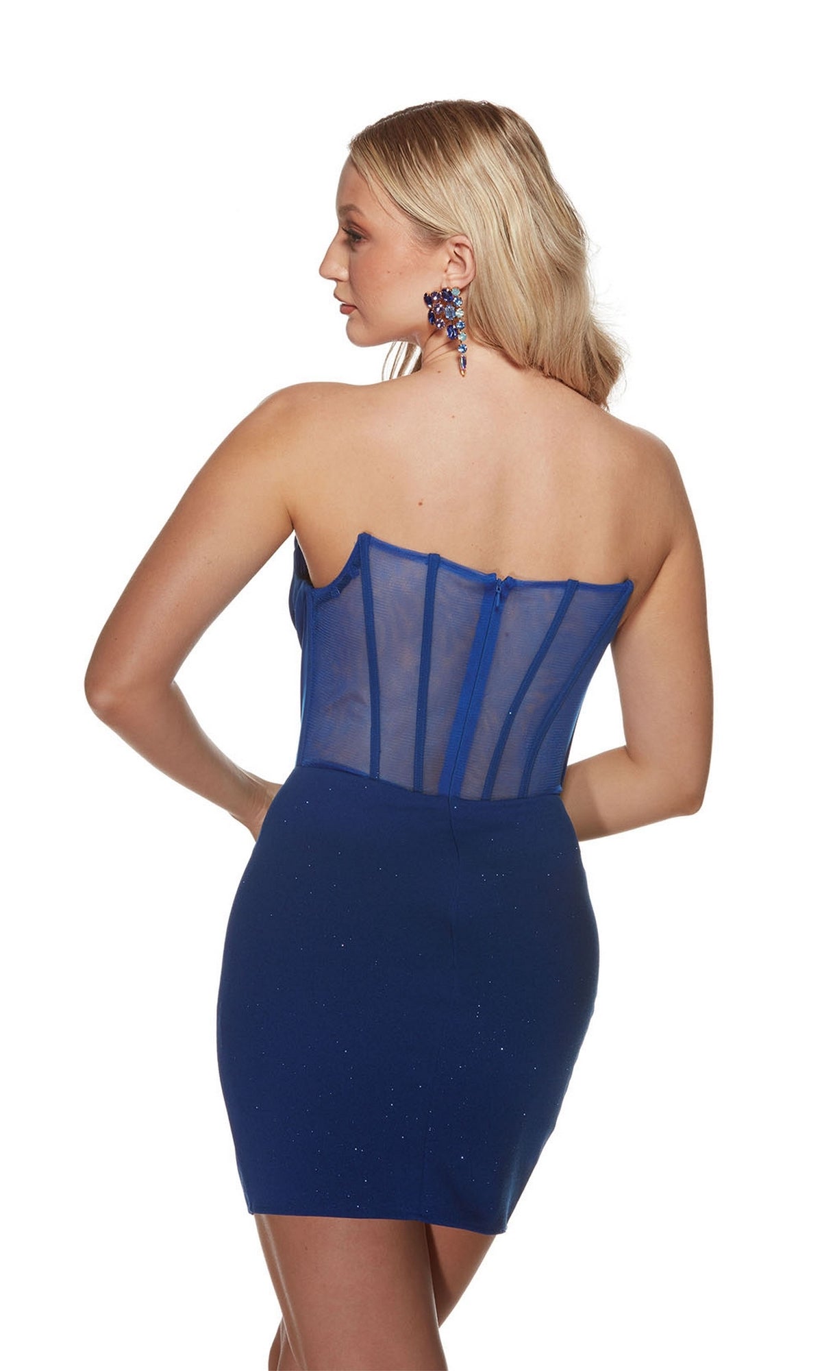 A woman with long blonde hair wears the Alyce Off-Shoulder Short Glitter Hoco Dress 4819, a form-fitting blue dress with a sheer boned bodice and matching blue earrings, shown from the back against a white background.